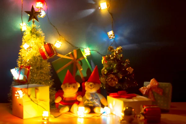 Desfocada e desfocada luz de Natal a noite de Felicidade. Enfeite de Natal feliz decorar com urso encantador, um presente, árvore de Natal e fita são o ornamento de Natal — Fotografia de Stock