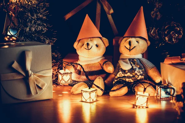 Ornament en teddy beer, kerst versieren bij Merry Christmas nachtlicht. Kerstboom en andere decoratie met mooi geschenk en lint — Stockfoto