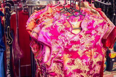 Qipao, cheongsam veya Çin Ulusal elbise satmak China Town, sokakta. İnsanlar bakmak ve Çin yeni yıl için satın almak.