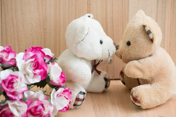 Abraçar ursos no amor sentar perto buquê rosa . — Fotografia de Stock