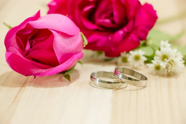 Engagieren Ring legte in der Nähe von roten Rosen auf Holz Hintergrund — Stockfoto