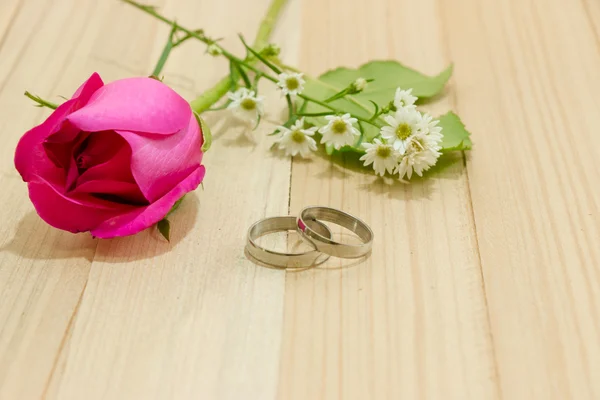 Engagieren Ring legte in der Nähe von roten Rosen auf Holz Hintergrund — Stockfoto