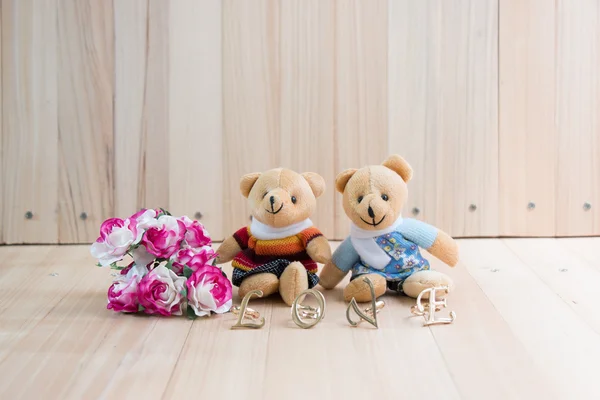 Beren in liefde te omarmen, zitten in de buurt van boeket roze. — Stockfoto