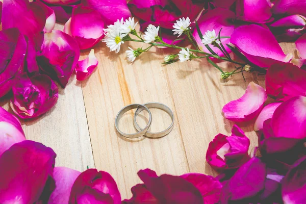 Ring zwischen Blütenblatt Rose auf Holz Hintergrund setzen — Stockfoto