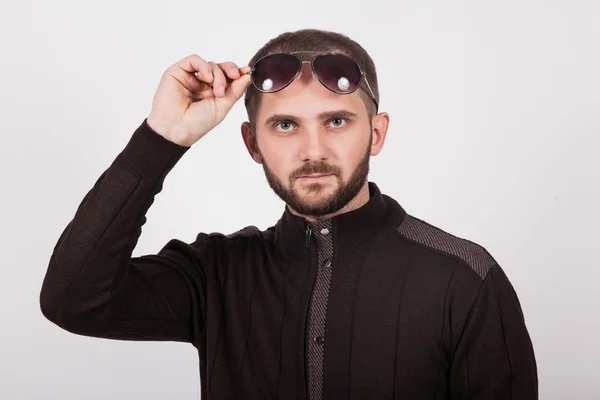 Adam bir sakal ve gözlük, beyaz bir arka plan üzerinde kahverengi bir ceket