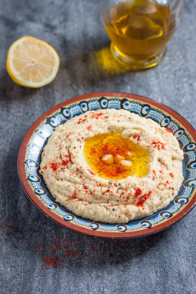 Klassischer Hummus mit Olivenöl und Zitrone auf dem Teller — Stockfoto
