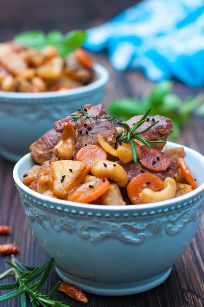 Азиатская кухня. Свинина с морковью, ананас, орехи кешью — стоковое фото