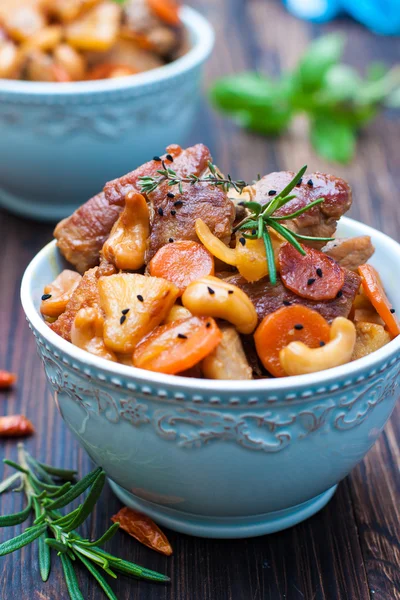 Cocina asiática. Cerdo con zanahoria, piña, anacardos — Foto de Stock