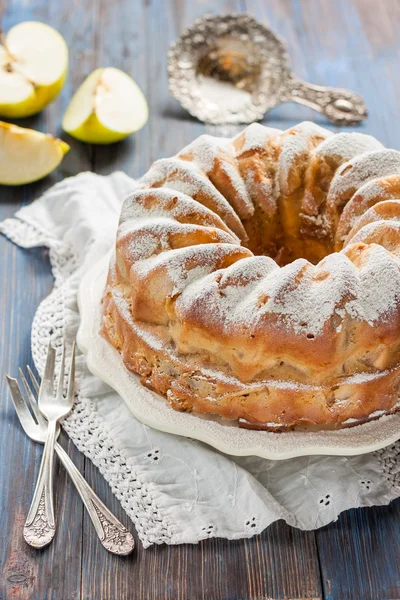 Apple pie. Charlotte. Cake with apples and powdered sugar on a blue wooden background