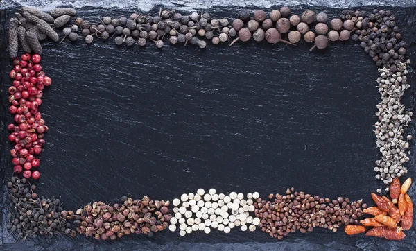 Surtido de todo tipo de pimienta seca sobre un fondo — Foto de Stock