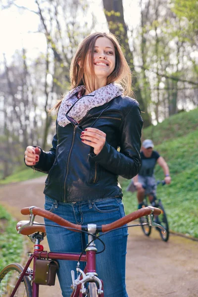 Bella giovane donna con bicicletta — Foto Stock