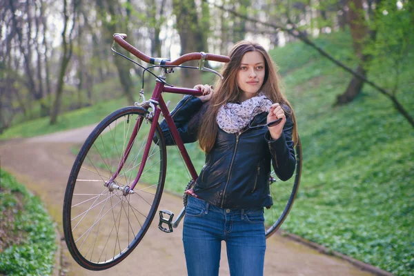 Bella giovane donna con bicicletta — Foto Stock