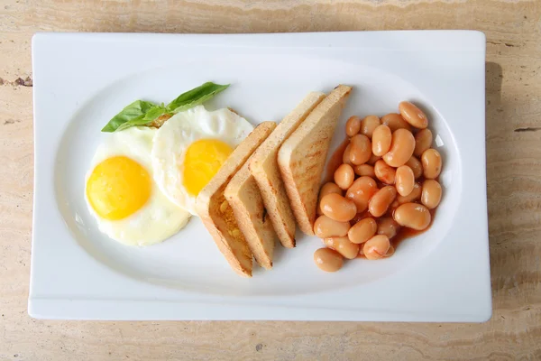 Завтрак: яичница, бобы и тосты — стоковое фото