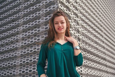 Genç kadın ayakta metal Delikli panel arka planda