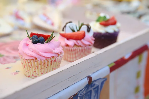 Delicioso cupcake de vainilla con glaseado de fresa y fresas frescas y arándanos —  Fotos de Stock