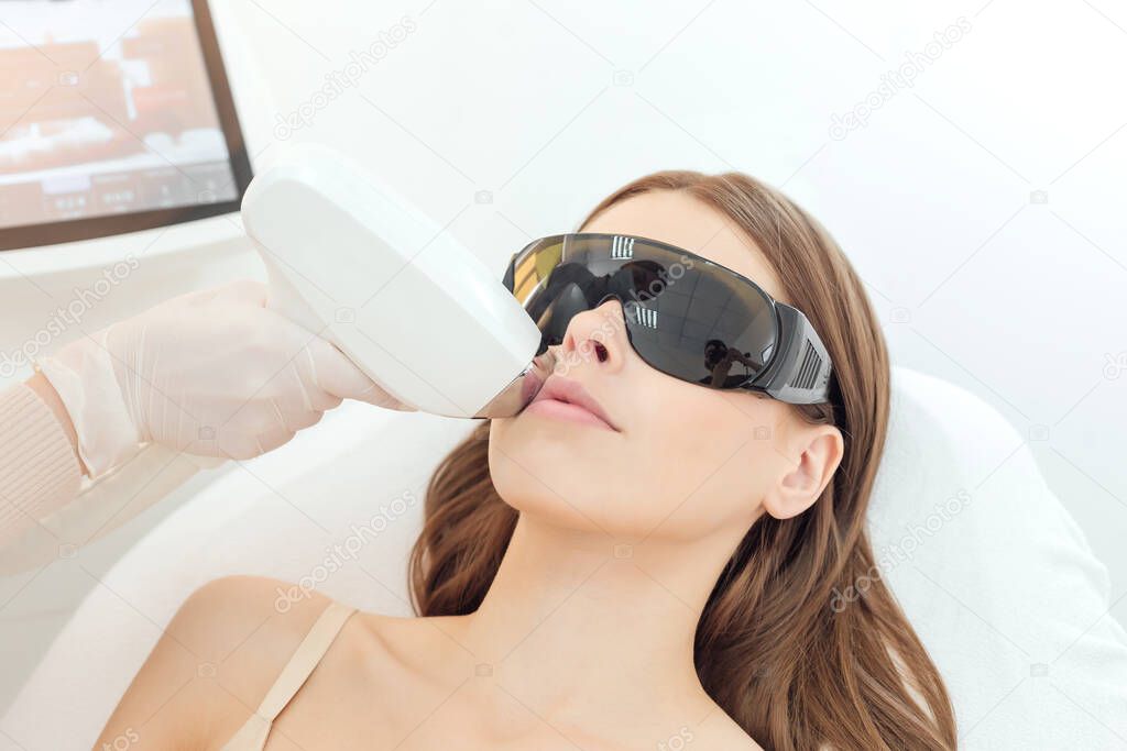 Woman has a laser epilation and cosmetology procedure