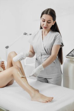 Beautician make a laser epilation and cosmetology procedure