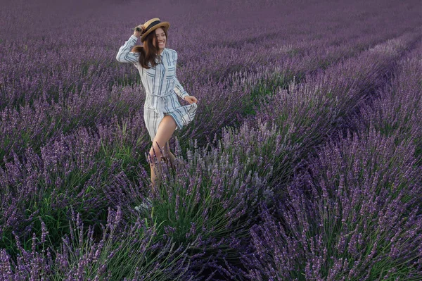 Jeune femme avec bouquet de lavande sur fond de champ de fleurs violettes — Photo