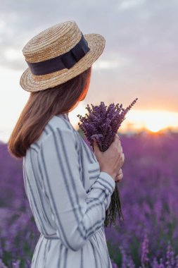 Lavanta tarlasında günbatımı arka planında genç bir kadının portresi