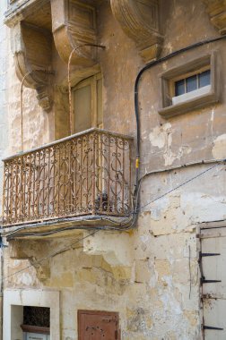 Maltalı bir politikacı olan Enrico Mizzi 'nin 20 Aralık 1950' de öldüğü eve ait bir plaket. Binada yıpranmış bir balkon ve geleneksel mimari yer alıyor..