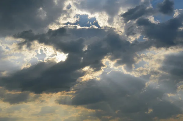 Os raios do sol brilham através das nuvens escuras — Fotografia de Stock