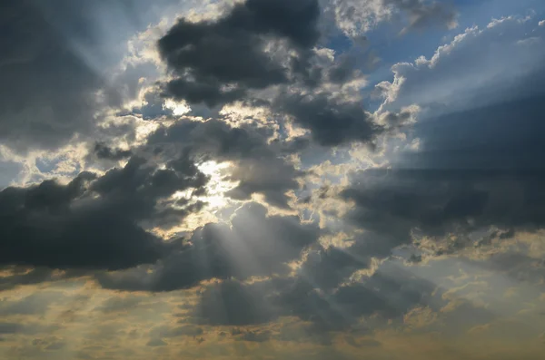 Солнечные лучи светят сквозь тёмные облака. — стоковое фото
