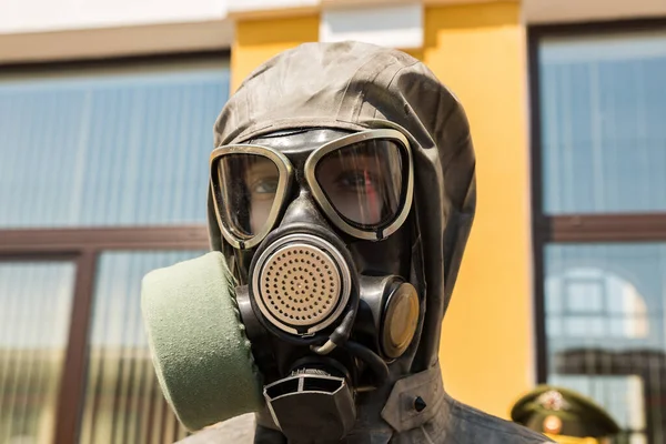 Mannequin head with a gas mask and a hood of a protective clothing set close up