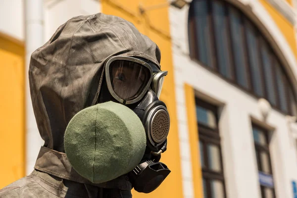 Mannequin head with a gas mask and a hood of a protective clothing set close up