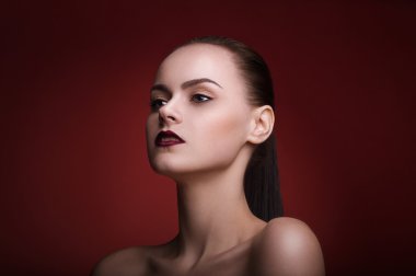 Kırmızı arka plan üzerinde makyaj ve kırmızı dudaklar ile genç güzel kadın Stüdyo portresi