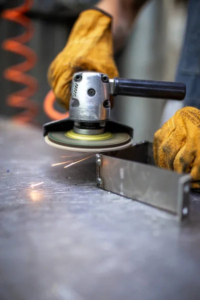 hands work grinder tool on a metal surface
