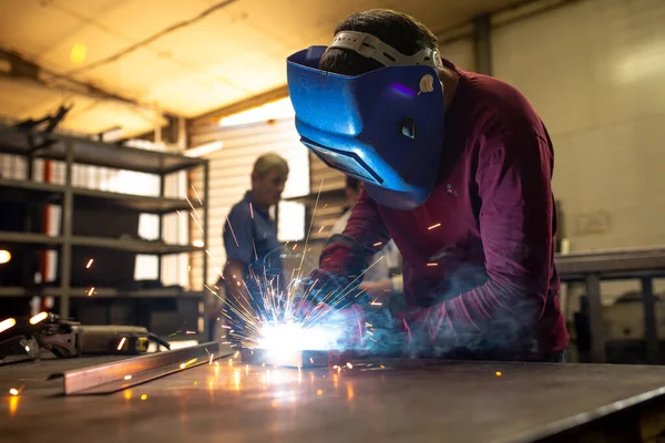 Kaynakçı metal bir yüzey üzerinde çalışır.