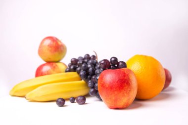 Still life of fruits on a white background, banana, apple, grapes.