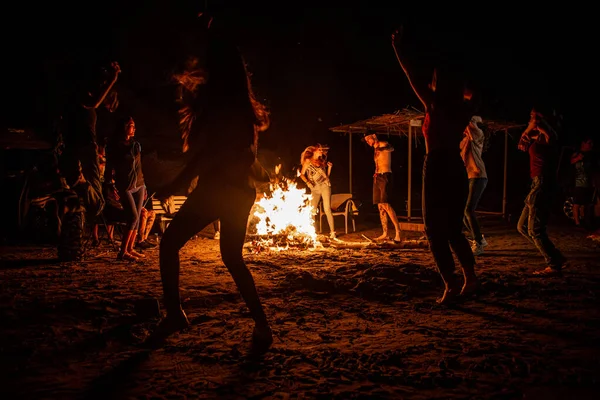 dancing near the fire at night in summer.