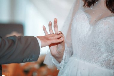 Yeni evliler törende alyans takarlar..