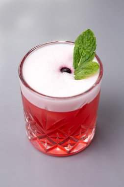 Gri arkaplanda naneli kırmızı kokteyl.