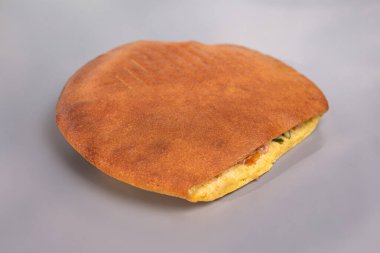 Gri bir arka planda yuvarlak bir düz ekmek içinde donör.