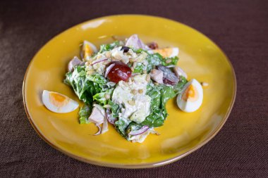 Sarı tabakta çırpılmış yumurta ve fındıklı salata.