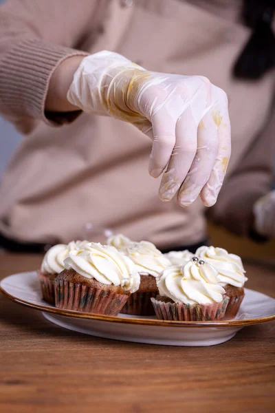 making cupcakes with cream close-up with the hands of the chef.