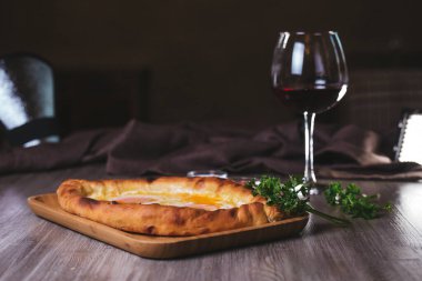 Kafedeki masada yumurtalı, otlu ve şaraplı Khachapuri.