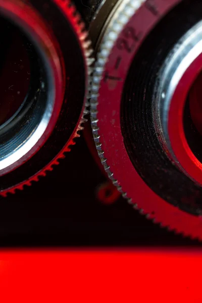 retro camera gears close-up on a red background.