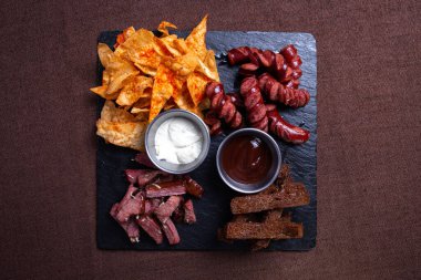 Barda bira, sosis, et ve cipsli kraker..