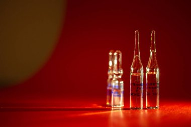 Kırmızı arka planda tıbbi enjeksiyon tüpleri