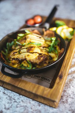 Tahta tezgahta domatesli kızartma tavasında patates kızartması..