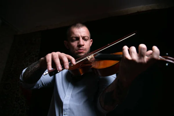 male violinist masterfully plays the violin