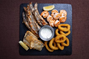 Bira için abur cuburlar siyah tabakta balık ve soğan halkaları