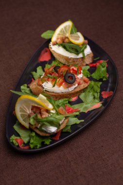 Krem peynirli, siyah tabakta zeytinli.