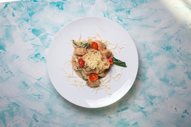 Sert peynirli makarna ve arkasında şarap olan et.