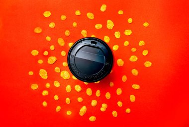 Yukarıdan kırmızı arkaplan manzaralı mısır gevrekli bir fincan kahve..