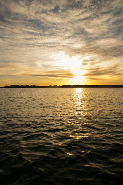 空に雲が浮かぶ海の美しい黄金の夕日 — ストック写真