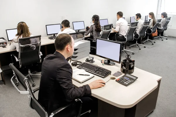 office workers at work on computers in the workplace.